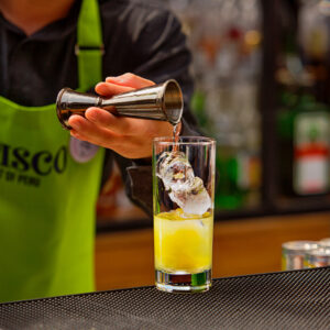 Barman preparando cóctel a base de pisco en el bar Curandero en Mercado 28